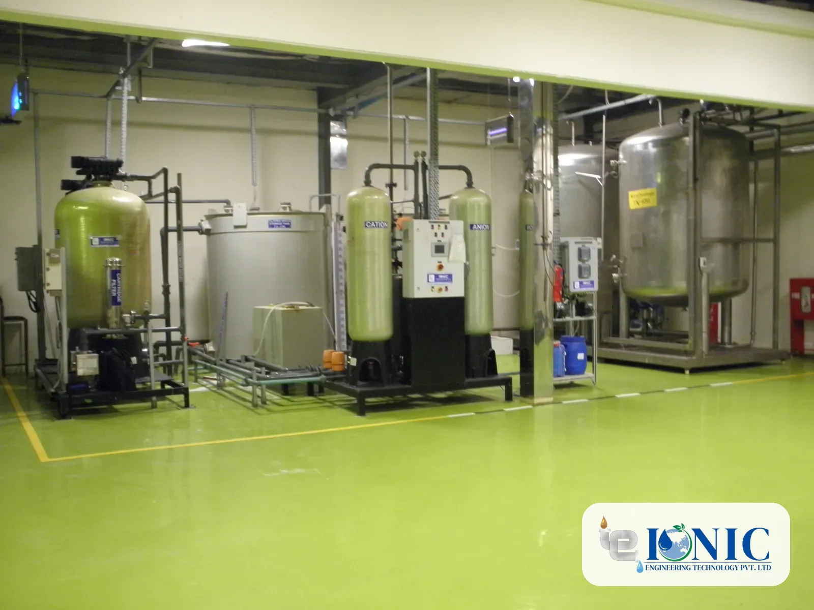 Demineralisation plant with cation and anion vessels, a control panel and stainless steel tanks